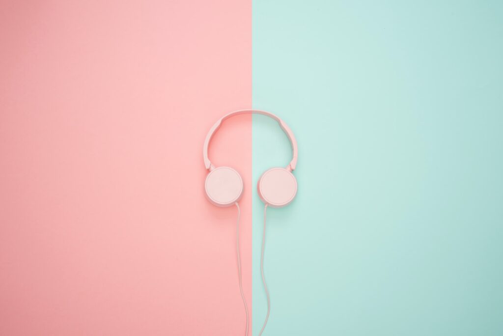 Pink headphones on a pink and green background.
